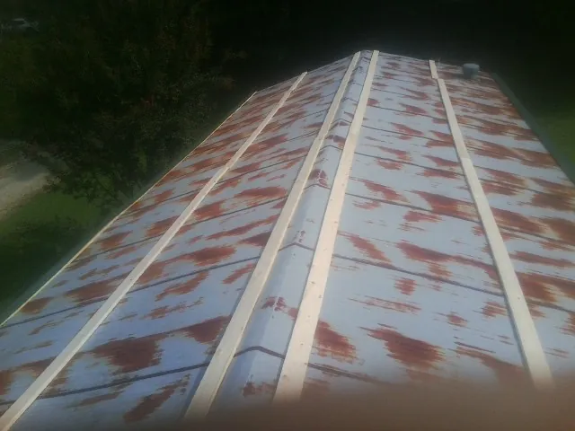 Rusted metal roof panels with new wood purlins before replacement — Storm Damage Roof Repair in Mayfield by Roofing Brothers