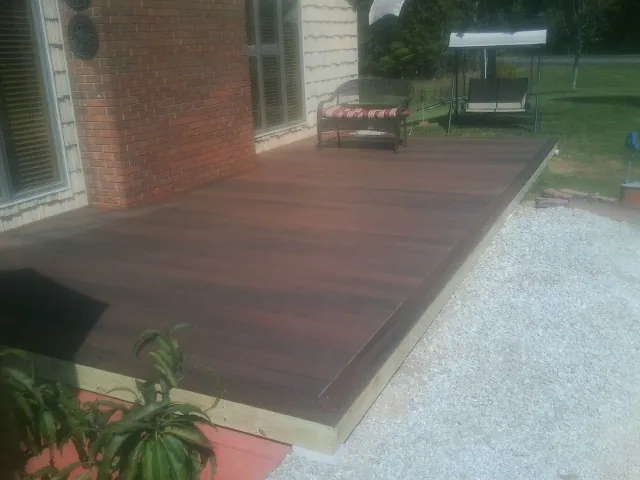 Freshly stained wood deck built against a brick home in Mayfield