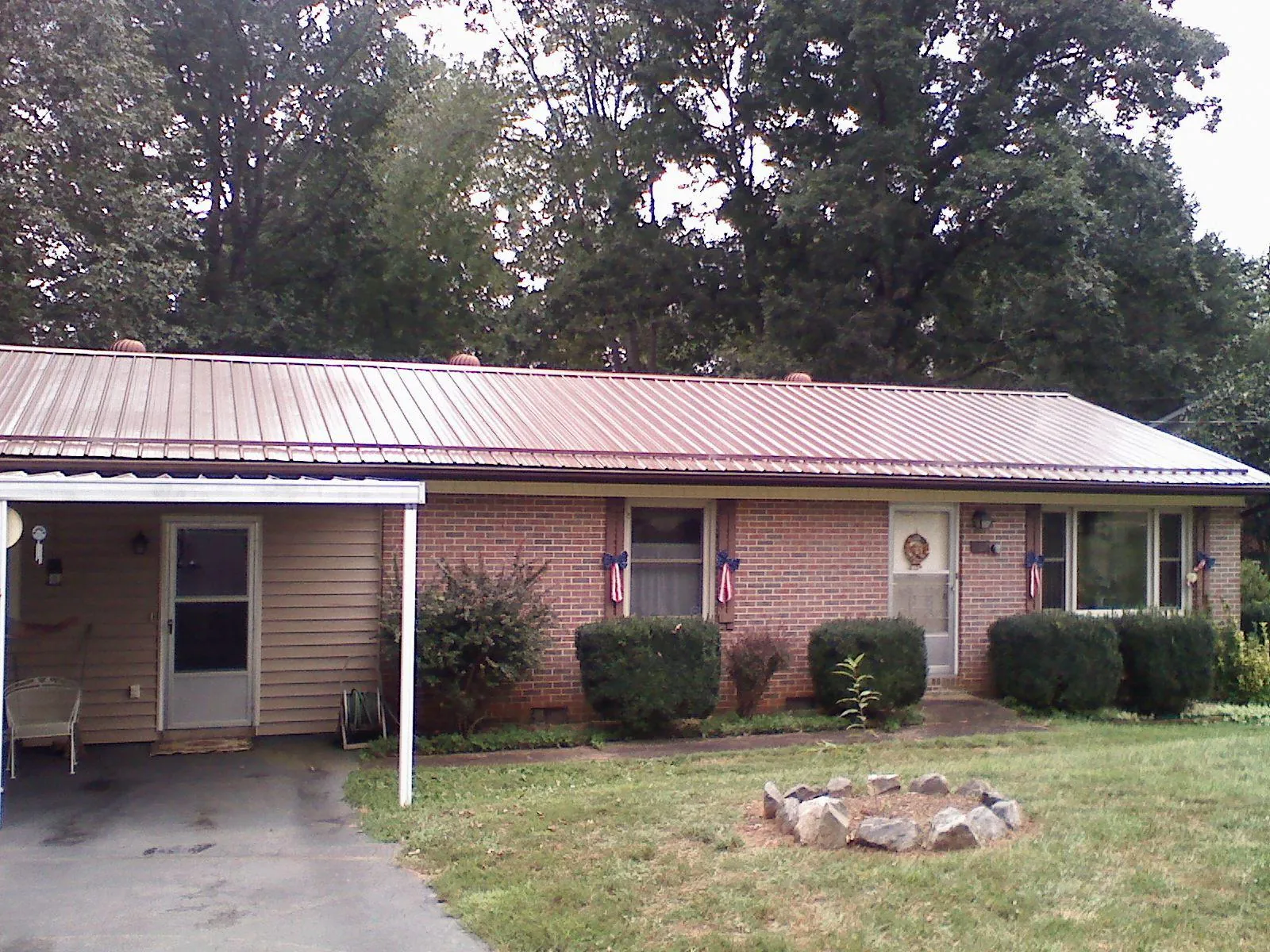 Bronze metal roof and carport on a brick ranch home — Roof Repair work by our crew in Mayfield